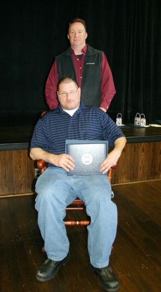 Penn State Hazleton Maintenance Worker David Phillips received a Penn State rocking chair to commemorate his 25 years of service to the University. Standing is Maintenance Supervisor Michael Chura.